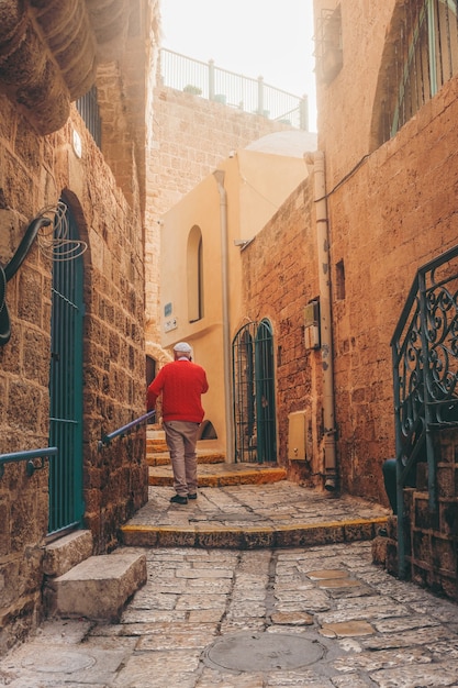 Man in blue jacket walking on sidewalk during daytime