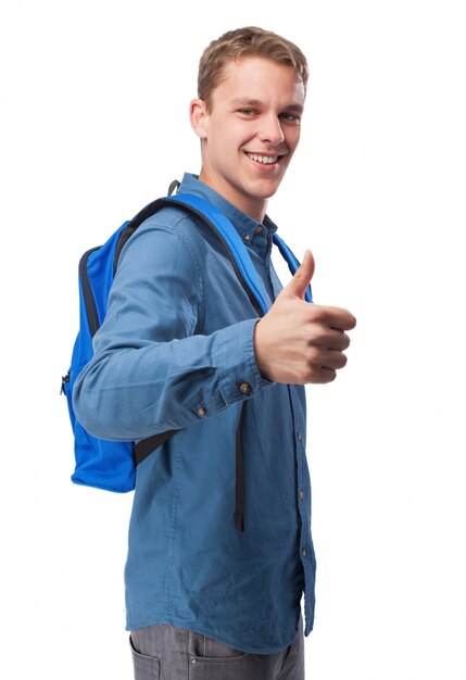 Man in blue shirt smiling and with a backpack