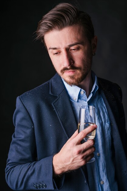 Man in blue standing with champagne glass in hand