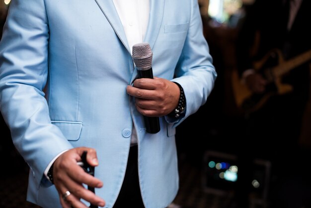 Man in blue suit holds a microphone