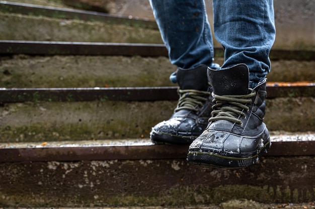 Free photo a man in boots on the old steps closeup