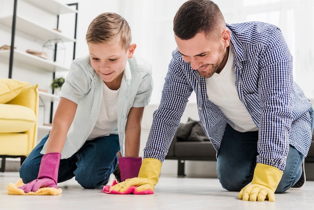 Free photo man and boy cleaning the floor