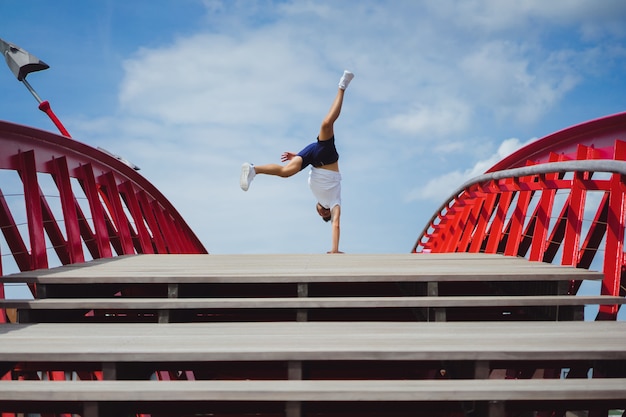 Free photo man on the bridge. handstand breakdance