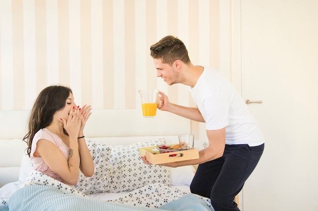 女性、ベッドで朝食を取る男性