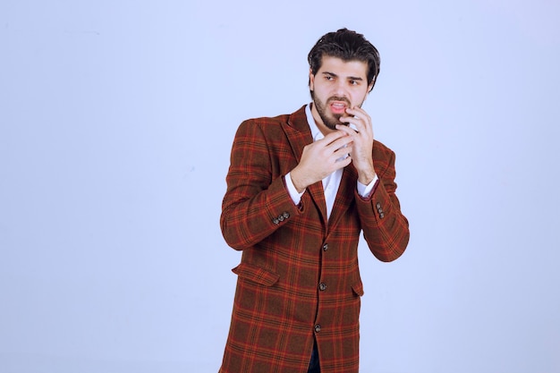 Man in brown blazer looks thrilled and scared