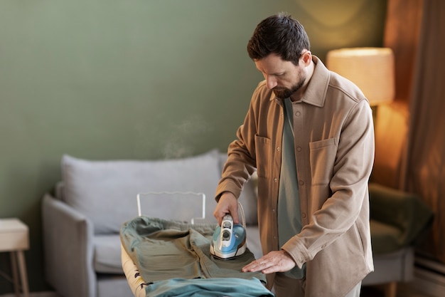 Free photo man in brown tshirt ironing