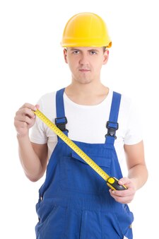 Man builder in blue coveralls holding measure tape isolated on white background