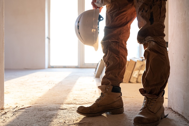 A man builder with a helmet in his hands copy space