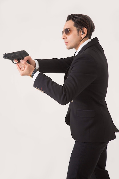 Man in business suite and gun on white background