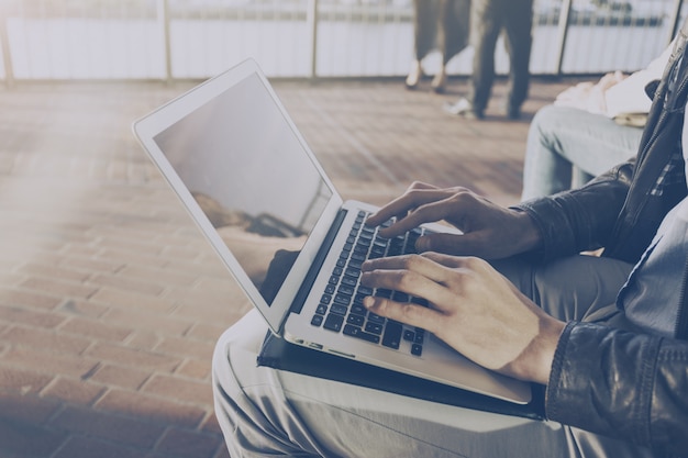 Free photo man businessman freelancer working on his laptop outdoors