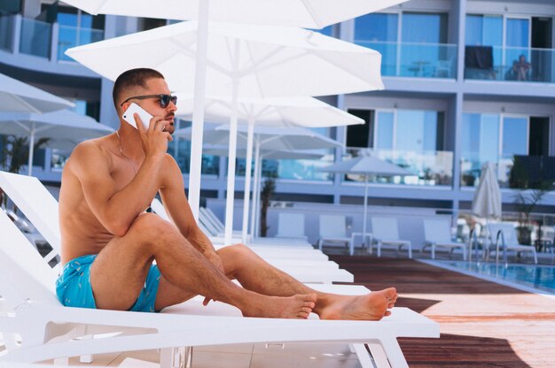 Man by the pool with phone