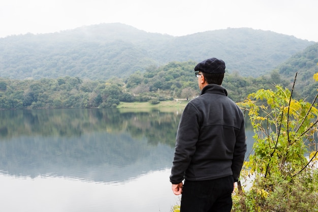 無料写真 風景を楽しんで湖のそばの男