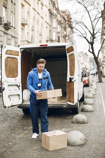 Foto gratuita uomo vicino al camion. ragazzo in uniforme da consegna.