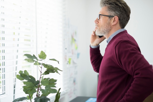 Man calling client next to the window