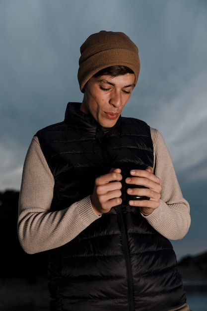 man camping and holding a cup of tea