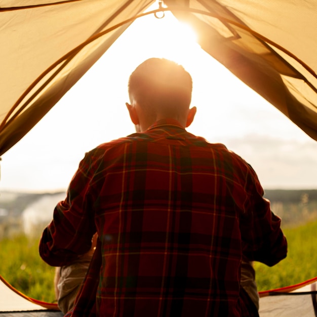 Man in camping tent at sunset