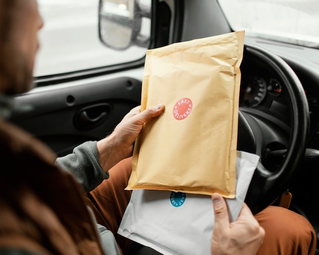 Free photo man in car delivering package close up