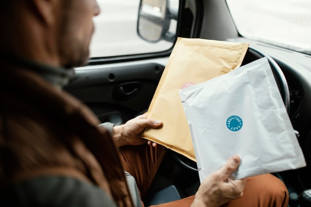 Free photo man in car delivering package close up