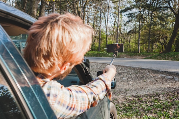 Man in car pointing ahead