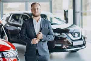 Free photo man in car showroom choosing a car