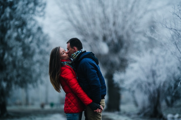 Man carries his girlfriend on his back in the park