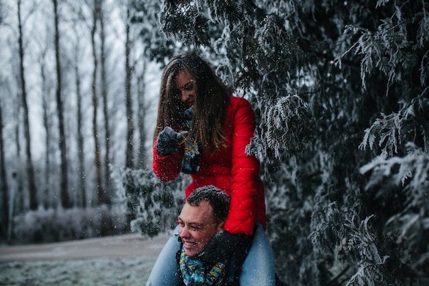 Man carries his girlfriend on his back in the park