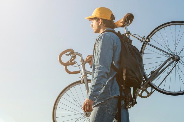 自転車のミディアムショットを運ぶ男