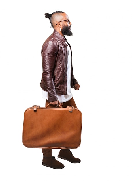 茶色のスーツケースを運ぶ男