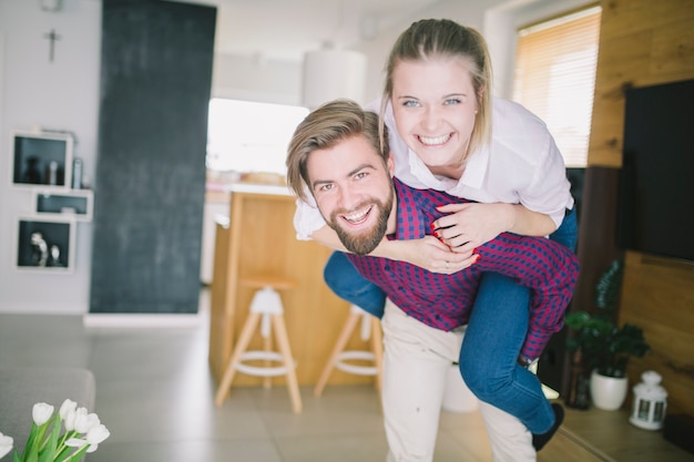 Free photo man carrying girlfriend on back