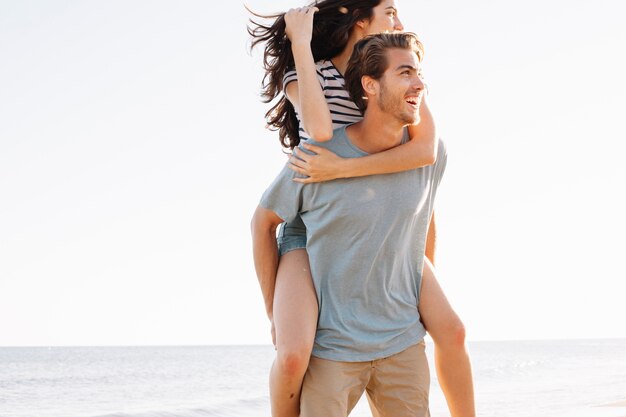 Man carrying girlfriend at the beach