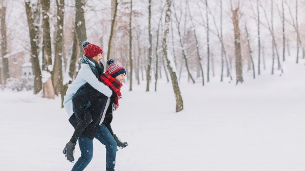 Man carrying girlfriend in snow