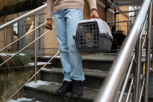 무료 사진 야외 캐리어에 자신의 애완 동물을 운반하는 남자
