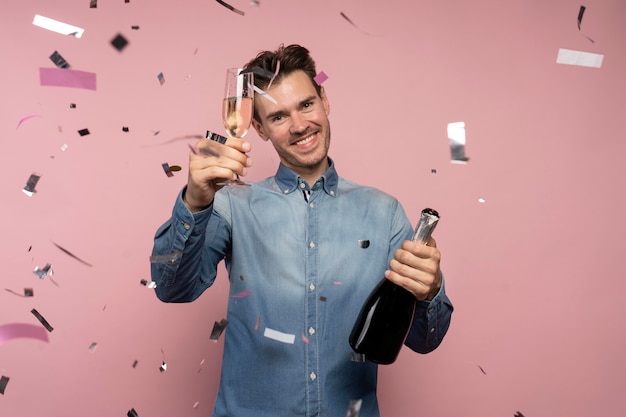 Человек празднует с бутылкой шампанского и бокалом