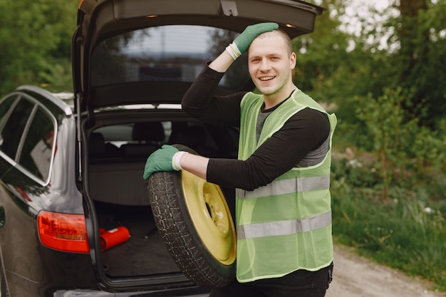 車の壊れたホイールを変更する男