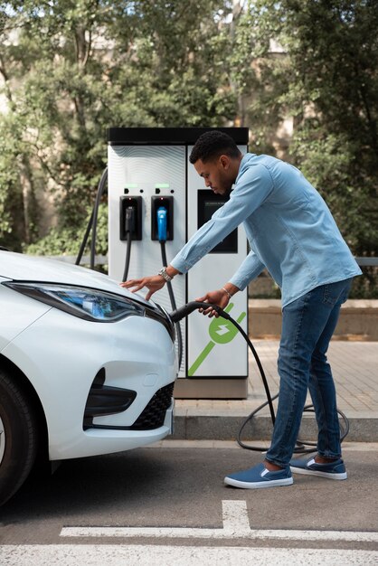 電気自動車のフルショットを充電する男