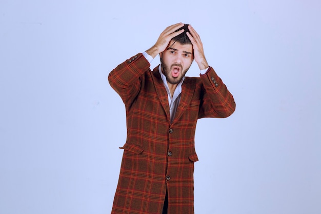 Man in checked jacket feeling very sad about something and crying.