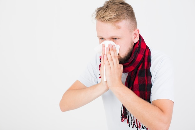 Man in checkered scarf blowing nose