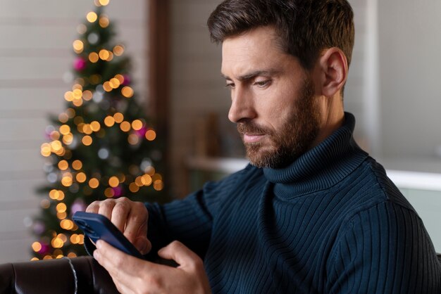 クリスマスの日に彼の携帯電話をチェックする男