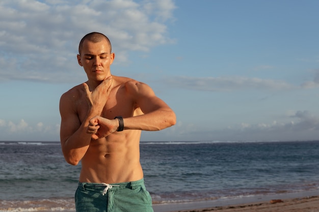 A man checks his pulse after training. bali