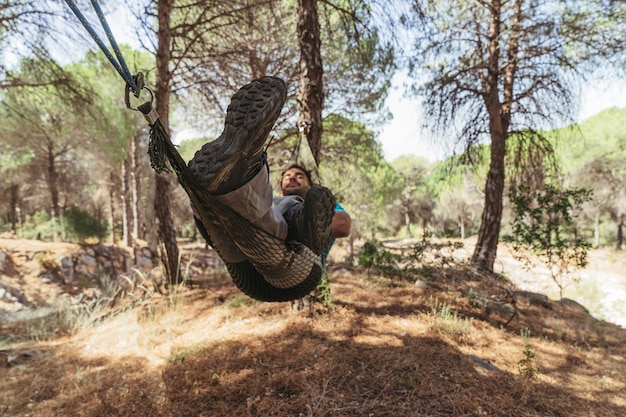 Man chilling in hammock in forest