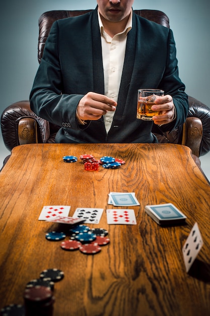 The man, chips for gamblings, drink and playing cards