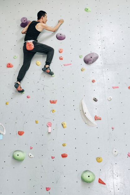 Man clambering wall alone