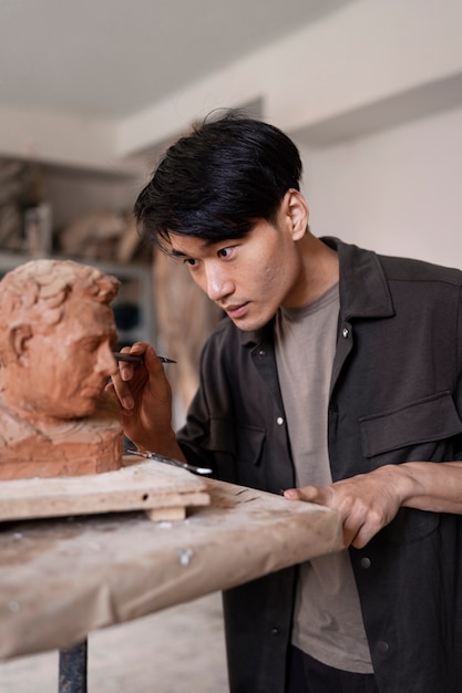 Man clay sculpting side view