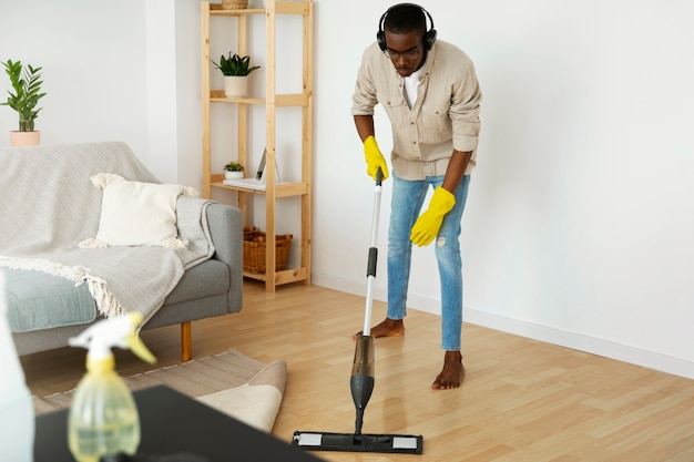 Man cleaning floor with mop full shot