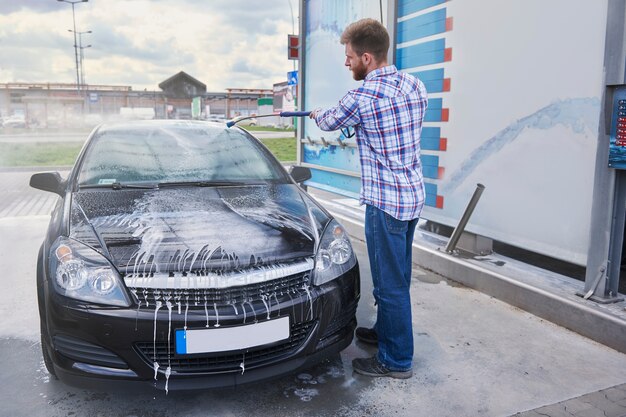 セルフサービスで車を掃除している男性