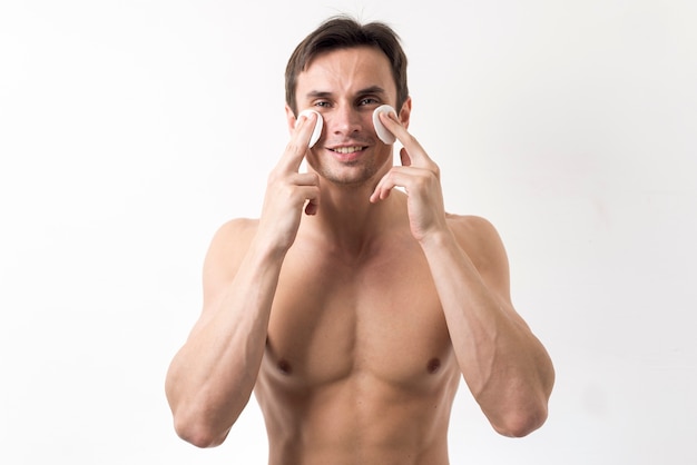 Man cleaning his face with cotton discs