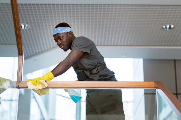 Man cleaning railing with cloth medium shot