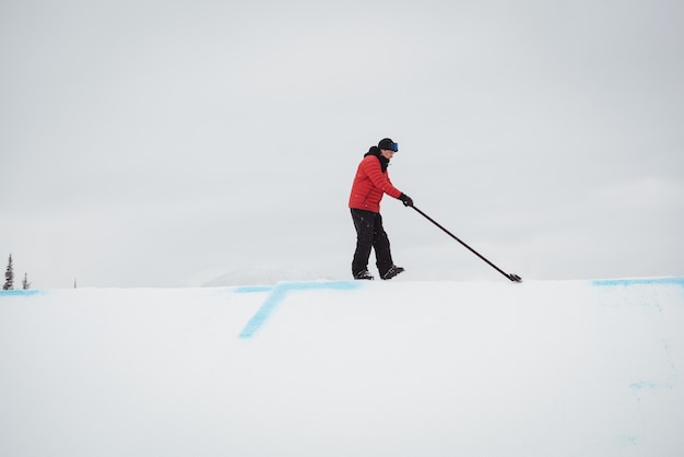 Free photo man cleaning snow in ski resort