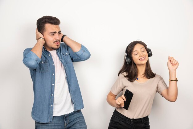 여자가 그녀의 마음을 노래하는 동안 그의 귀를 닫는 남자.