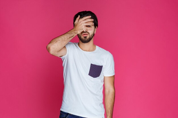 Man closing his face as he is tired and bored. 